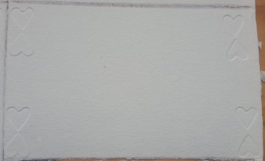 Carte de papier vergé blanc gaufré de cœurs.