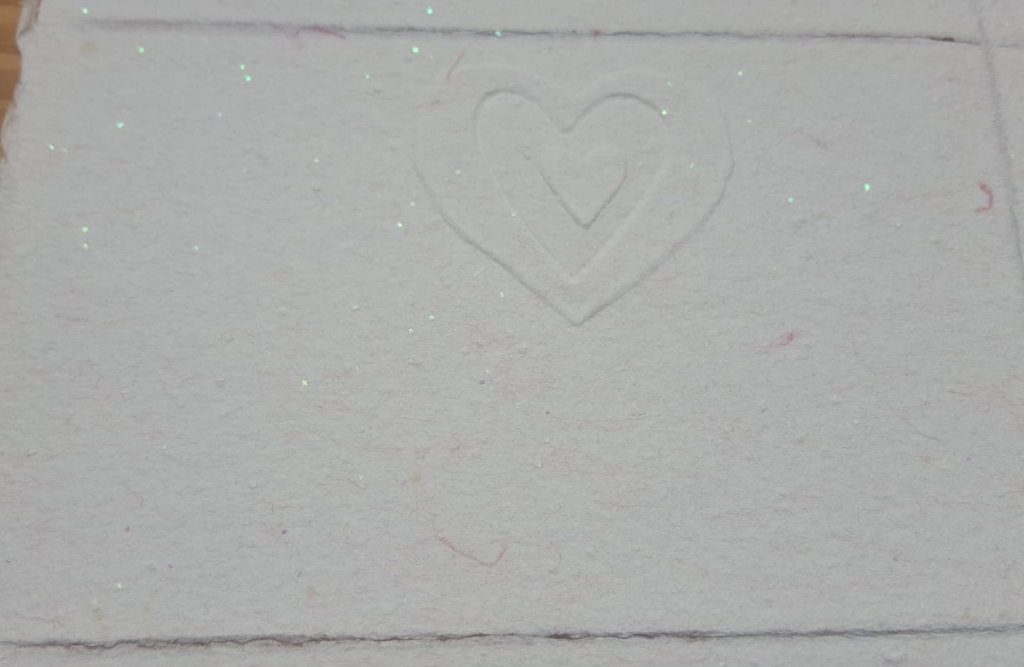 Un cœur dans un autre cœur pour cette jolie carte gaufrée rose pailletée.