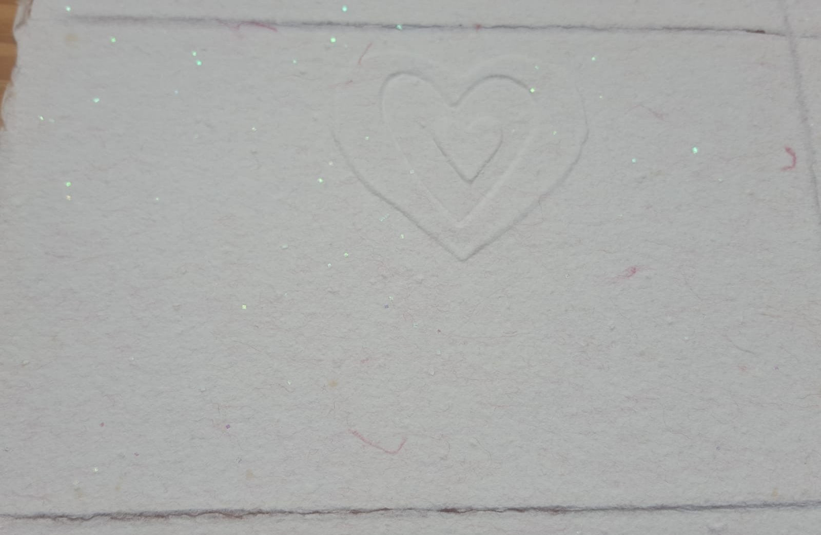 Un cœur dans un autre cœur pour cette jolie carte gaufrée rose pailletée.