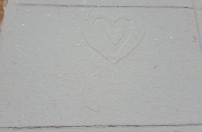 Un cœur dans un autre cœur pour cette jolie carte gaufrée rose pailletée.