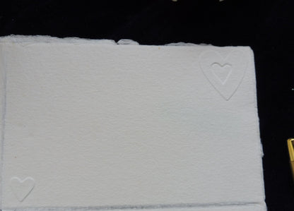 La carte nous 1 cœur dans un autre et un petit cœur seul en bas à gauche