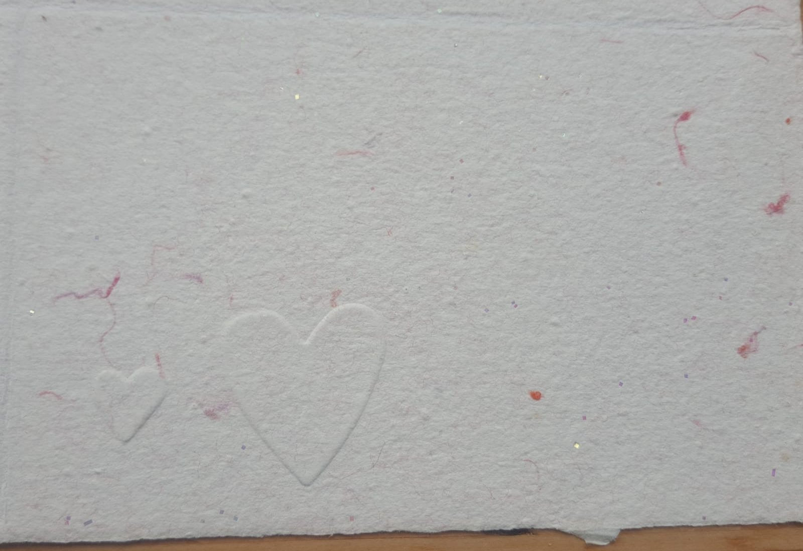 Carte gaufrée sur papier rose avec marque des fibres de coton rose