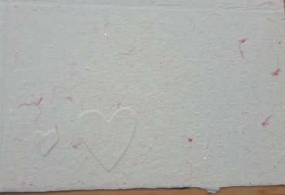 Carte gaufrée sur papier rose avec marque des fibres de coton rose