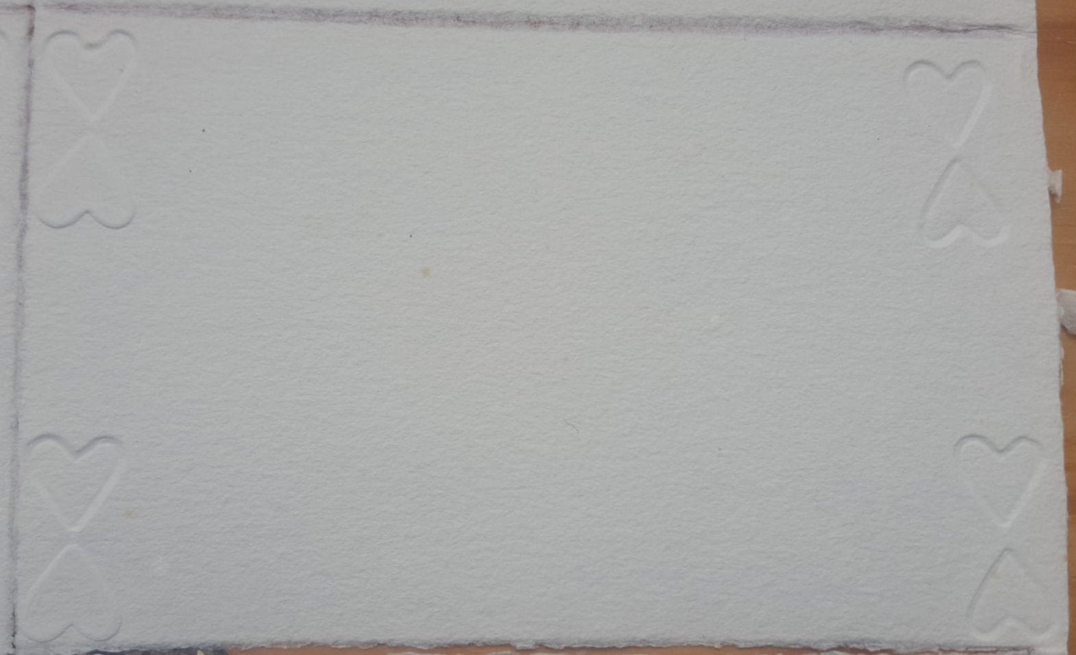 Carte de papier vergé blanc gaufré de cœurs.