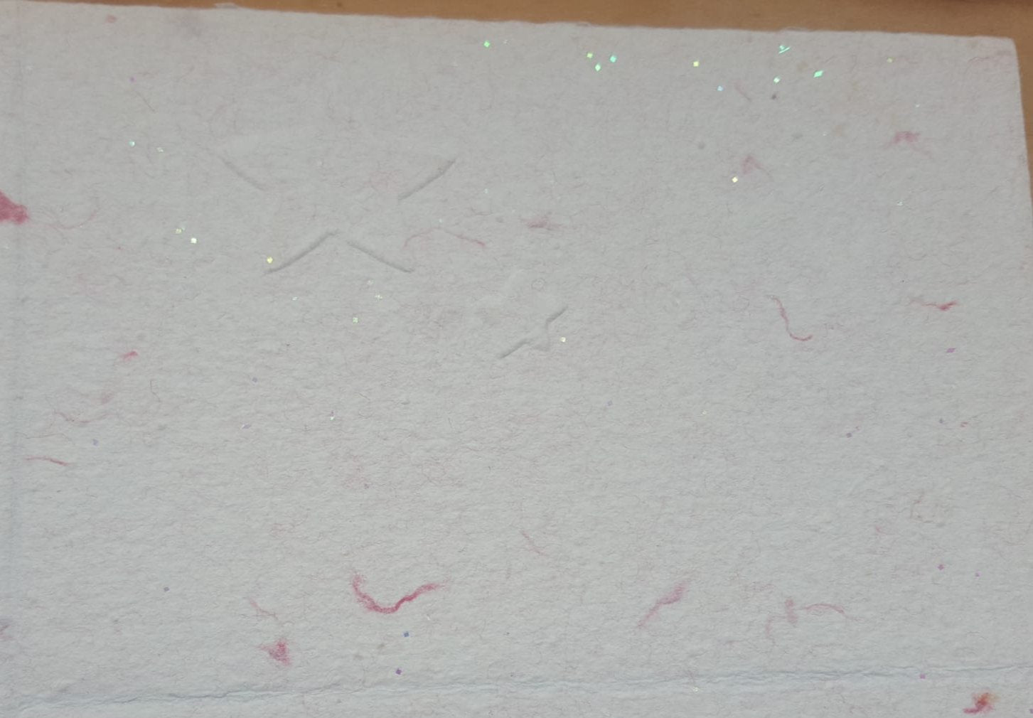 Une grande et une petite étoiles sur du papier vergé pailleté.